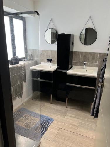 een badkamer met 2 wastafels en 2 spiegels bij Gîte chez marie in Bessèges