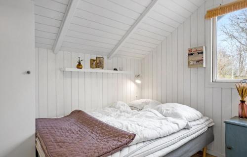 ThyholmにあるNice Home In Thyholm With 4 Bedrooms, Sauna And Wifiの窓付きの客室の白いベッド1台