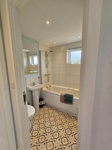 a bathroom with a tub and a toilet and a sink at Peacock Lodge - Sleeps 4 - 2 Bedrooms in East Looe
