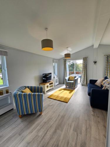 a living room with two couches and a television at Peacock Lodge - Sleeps 4 - 2 Bedrooms in East Looe