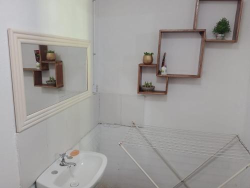 a white bathroom with a sink and a mirror at Esquina Sur in Esquina