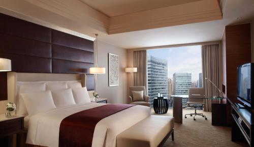 a hotel room with a bed and a large window at Shanghai Marriott Hotel Riverside in Shanghai