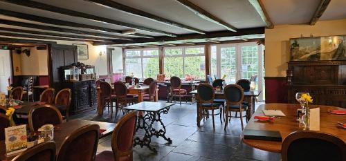- une salle à manger avec des tables, des chaises et des fenêtres dans l'établissement Trelawney Cottage, Sleeps up to 4, Wifi, Fully equipped, à Menheniot