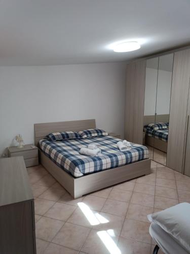 Schlafzimmer mit einem Bett und einem Spiegel in der Unterkunft Villino fiera di Roma e aeroporto Fiumicino in Ponte Galeria