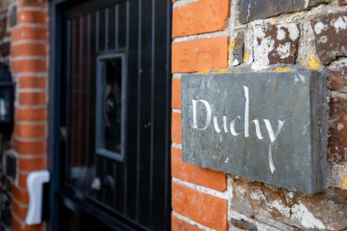 a sign on a brick wall with the word dudley at Treworgie Barton - Duchy in Bude