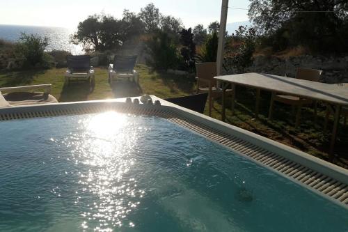 ein Swimmingpool im Hinterhof eines Hauses in der Unterkunft Bungalow Thalassa, am Strand und mit Mini-Pool in Kalamaki