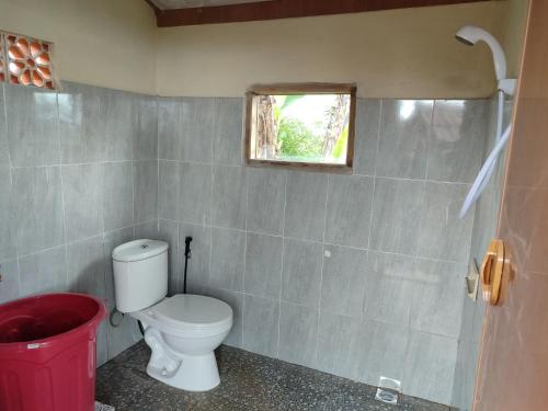 a bathroom with a toilet and a window at Bugo Camp Glamping & Natural Activity in Munduk