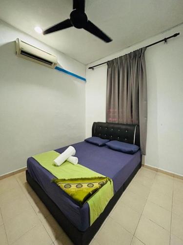 a bedroom with a bed with a ceiling fan at Homestay Pusat Bandar Kangar in Kangar