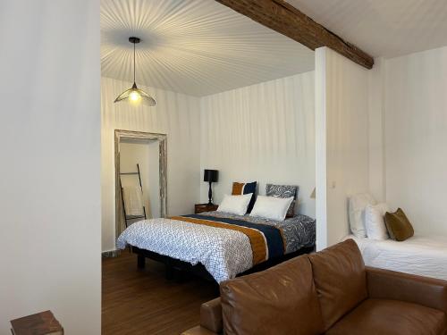 a living room with two beds and a couch at Un Petit Château in Lauzun