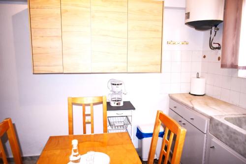 a small kitchen with a wooden table and chairs at Gianna Seaside in Koutsounari