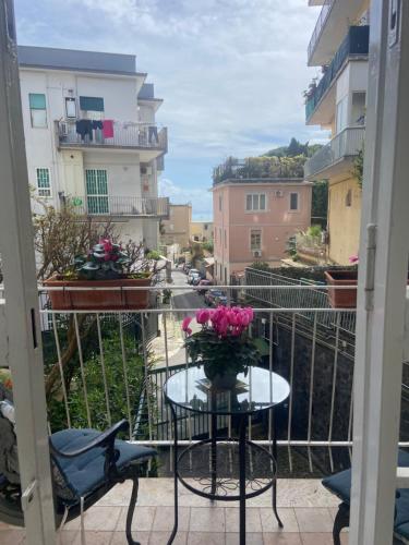un tavolo con un vaso di fiori sul balcone di Dana house a Napoli