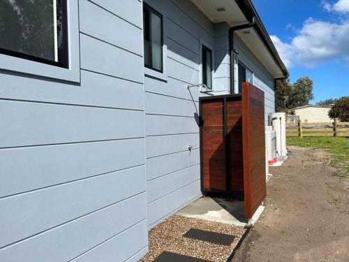 a garage with a red door on the side of a house at The Bloom in Seaspray