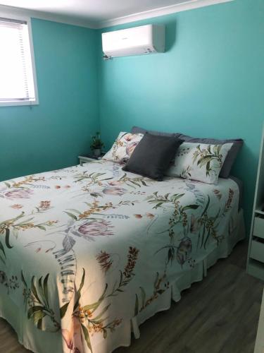 1 dormitorio con 1 cama con edredón blanco en Curra Cottage en Curra