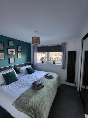 um quarto com uma cama grande e toalhas em Stylish home in Linlithgow em Linlithgow