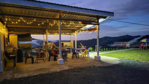 a group of people sitting under a pavilion with lights at Hawun Valley Kiulu in Tamparuli