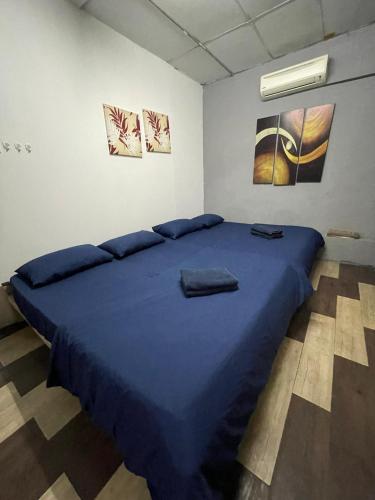 a bedroom with a large blue bed in a room at Art Motel Kulim in Kulim