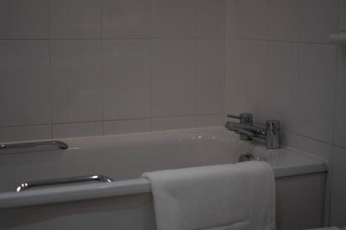 a bathroom with a bath tub with a towel at TQ luxurious 2 bed flat in Birmingham