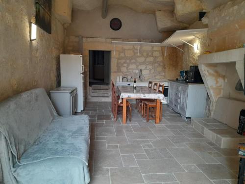 a kitchen with a table and chairs and a refrigerator at La troglodyte fantastique Lochoise in Loches