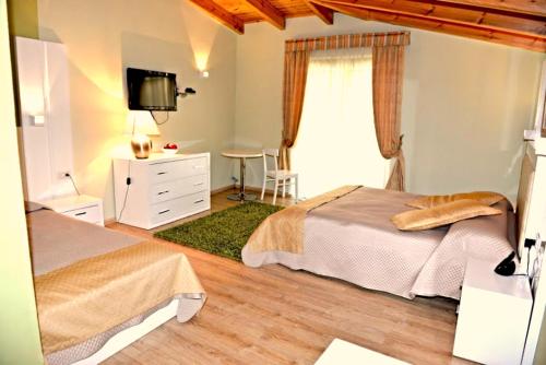 een slaapkamer met 2 bedden, een bureau en een televisie bij Hotel & Restaurant White City in Berat