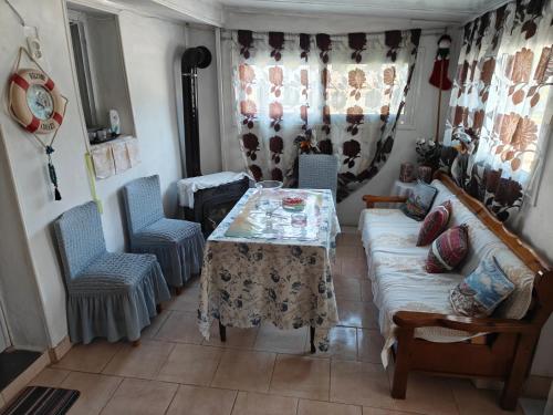 a living room with a table and chairs and a couch at ΜΟΝΟΚΑΤΟΙΚΙΑ ΣΑΛΑΜΙΝΑ in Áyios Yeóryios