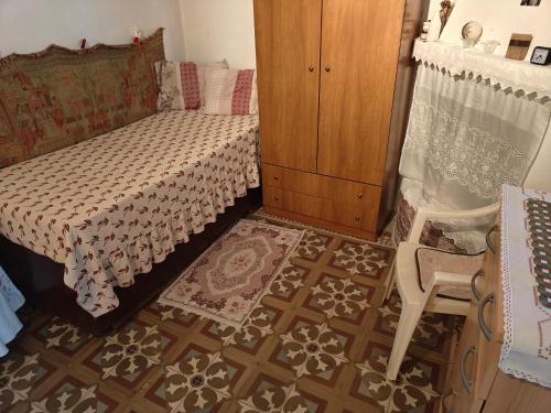 een slaapkamer met een bed, een dressoir en een stoel bij ΜΟΝΟΚΑΤΟΙΚΙΑ ΣΑΛΑΜΙΝΑ in Áyios Yeóryios