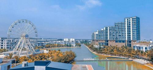 ein Riesenrad und ein Fluss in einer Stadt in der Unterkunft THE SUN HOTEL và VILLA FLC in Lôc Hải