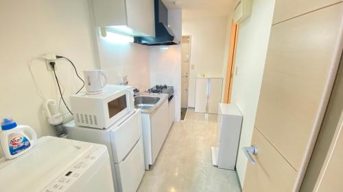 una cucina con un microonde e un lavandino di CON-TWO 201 a Tokyo