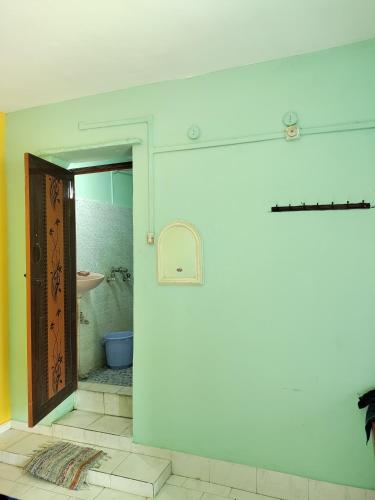 un baño con una puerta que conduce a un lavabo en Basama Complex, main road puttaparthi, en Puttaparti