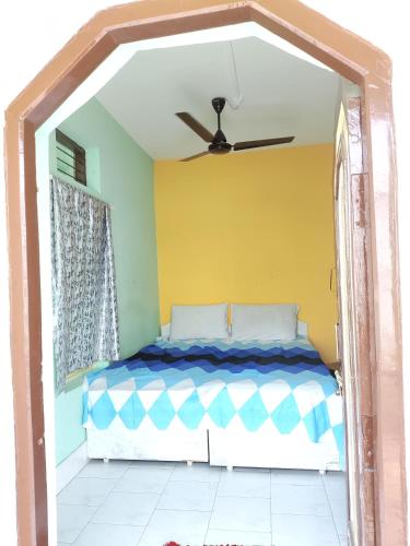 Cama en habitación con ventilador de techo en Basama Complex, main road puttaparthi, en Puttaparti