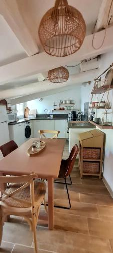 - une cuisine avec une table et des chaises dans la chambre dans l'établissement Appartement avec terrasse en centre-ville, à LʼIsle-sur-la-Sorgue