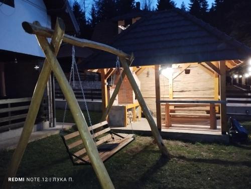 a wooden cabin with a gazebo at night at Planinska kuca Gora in Mitrovac
