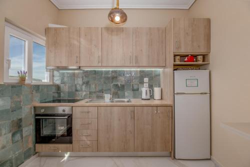 a kitchen with wooden cabinets and a refrigerator at Marina Zeas Skydeck in Piraeus