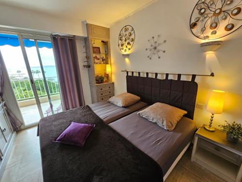 une chambre avec deux lits et un balcon dans l'établissement Superbe vue mer à 50 mètres des plages, à Cannes