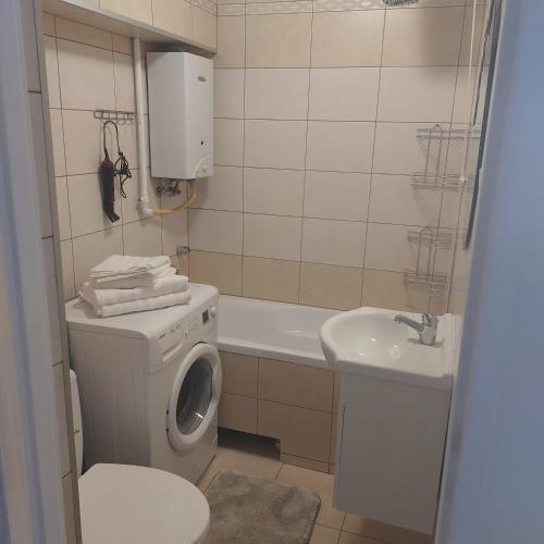 a bathroom with a washing machine and a sink at Apartament Mazurska in Kętrzyn