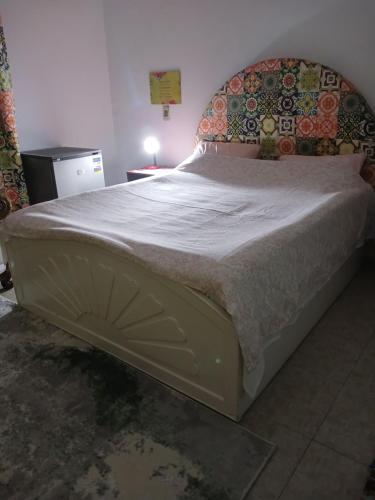 a large bed in a bedroom with a white mattress at GEM VIEW ROOMS in Qaryat ash Shamālī