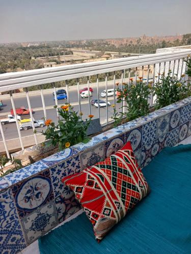 dwie poduszki siedzące na ławce na balkonie w obiekcie GEM VIEW ROOMS w mieście Qaryat ash Shamālī
