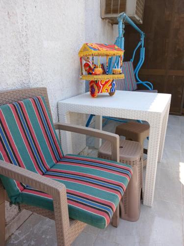 Una mesa blanca con dos sillas y una casa de juguete. en GEM VIEW ROOMS en Qaryat ash Shamālī