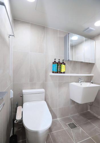 une salle de bains avec des toilettes blanches et un lavabo dans l'établissement Malang Home, à Séoul