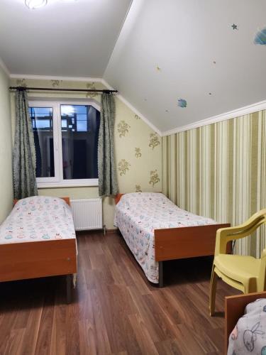 1 dormitorio con 2 camas y ventana en Guest house, en Uman