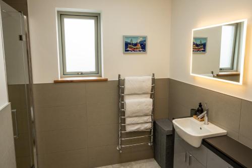 a bathroom with a sink and a mirror at Nana Cottage , Findhorn Village in Findhorn