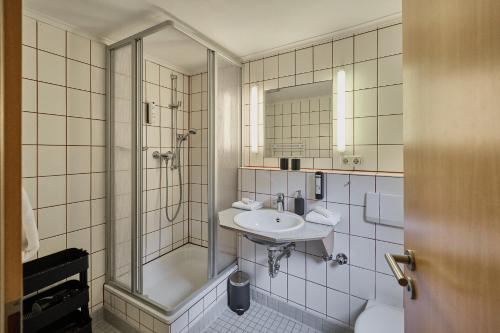 W łazience znajduje się prysznic i umywalka. w obiekcie Hotel Roter Hahn w Ratyzbonie