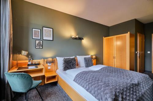 a hotel room with a bed and a desk and a bed sidx sidx sidx sidx at Hotel Roter Hahn in Regensburg