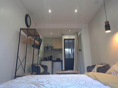 ein Schlafzimmer mit einem Bett und einer Küche und einem Spiegel in der Unterkunft Sweet / Circuit 24h / Moto GP / Antares / Oasis - centre des expositions / Boulerie Jump in Le Mans