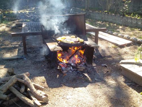 a grill with a pan of food on top of a fire at Casa Badinot in Diano dʼAlba