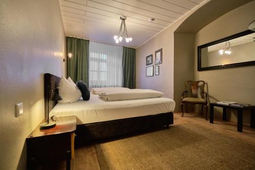 1 dormitorio con cama, escritorio y silla en Hotel Roter Hahn, en Regensburg