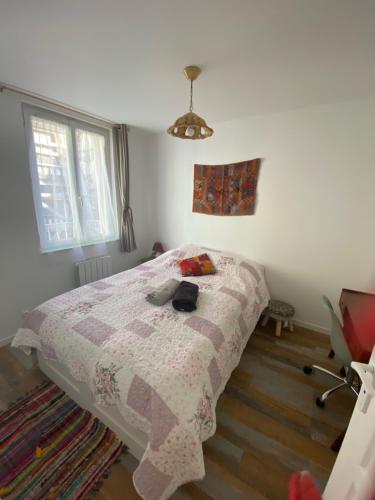 a bedroom with a bed with a quilt on it at Chez Moon centre ville historique in Vernon