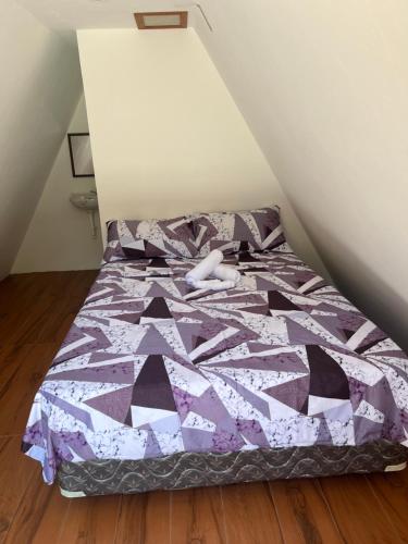 a bed with a purple comforter in a room at Fun Da House in San Juan