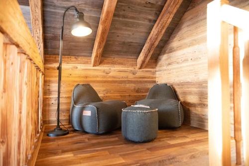two chairs and a lamp in a room with wooden walls at Holzfäller-Chalet in Obdach