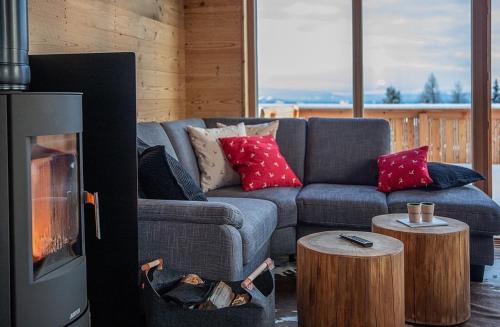 a living room with a couch and a fireplace at Holzfäller-Chalet in Obdach
