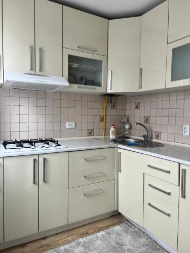 a white kitchen with white cabinets and a sink at ИП.МЕДИНА in Taraz